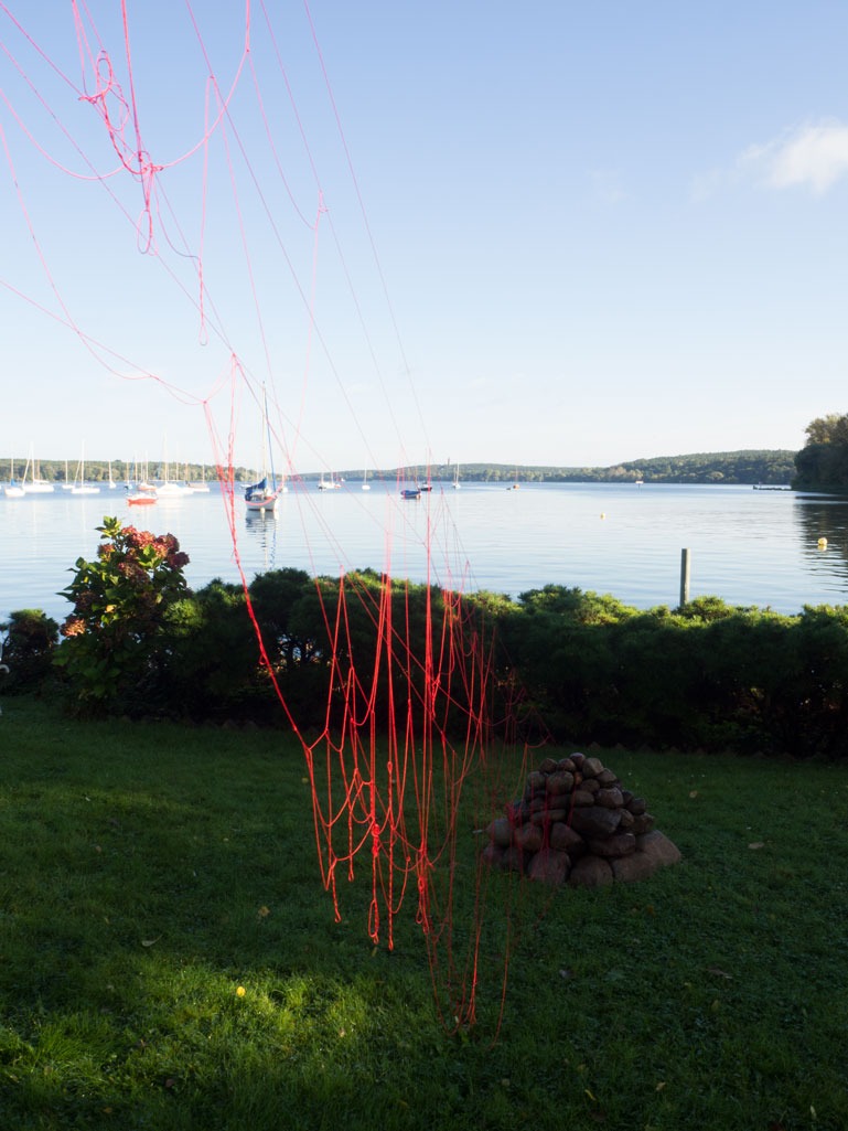 ANJA ASCHE. Oberfläche – Installation, Messingscheibe, Messingstab, roter Faden, Masse variabel, 2021. Surface – Installation, brass disc, brass rod, red thread,
   mass variable, 2021 